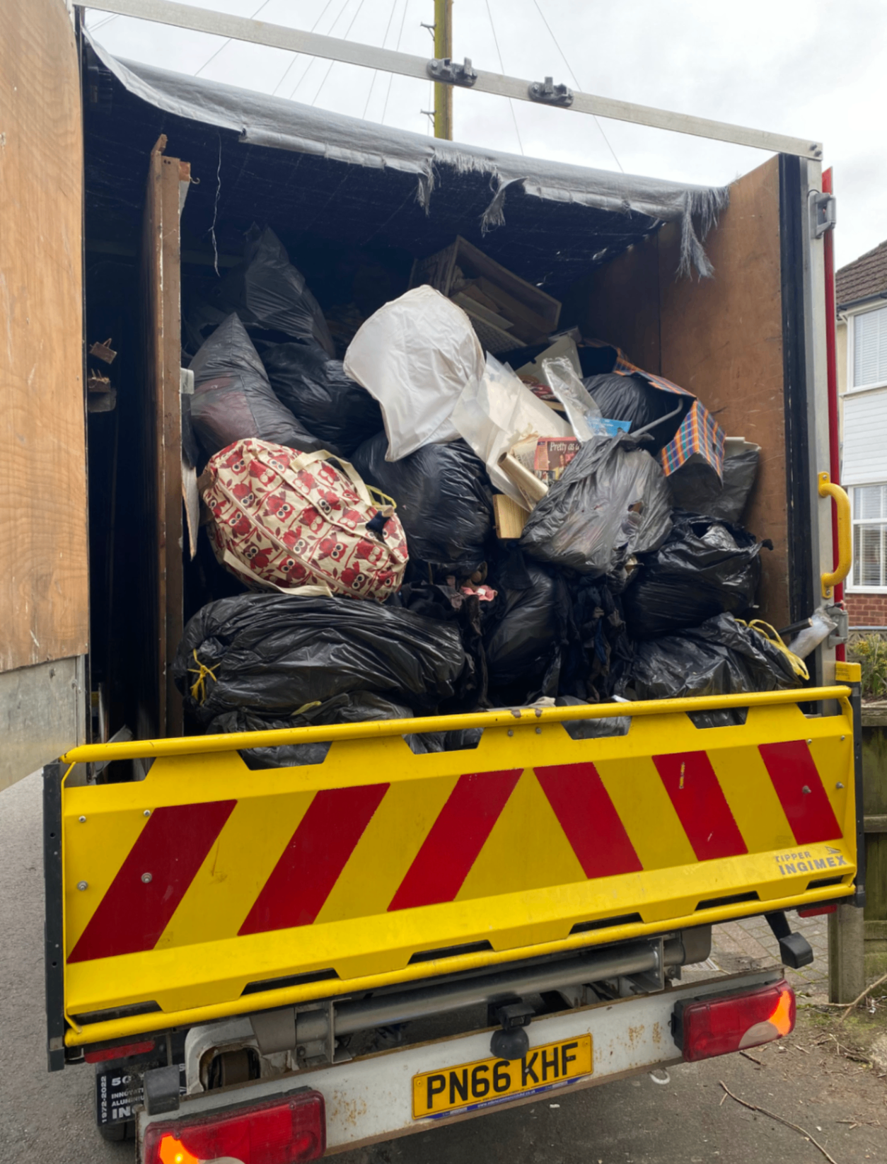 Truck filled with bagged household waste during a clearance job
