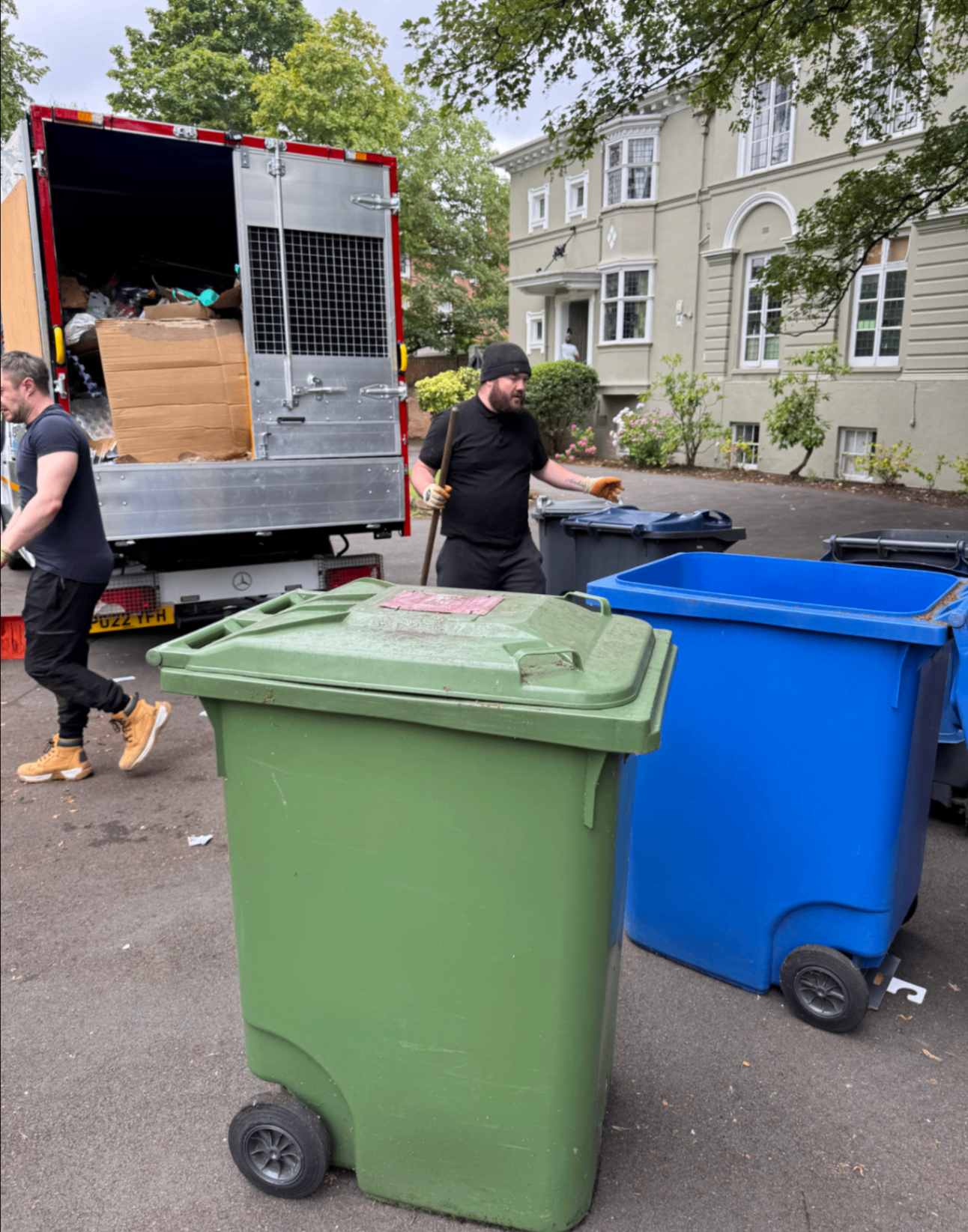 LV81 Removals team clearing wheelie bins beside a loaded tipper van